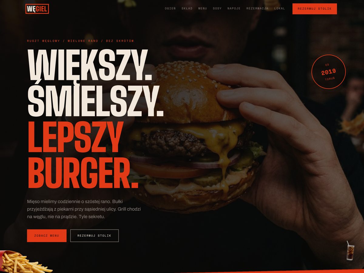 Strona WĘGIEL: nagłówek Większy. Śmielszy. Lepszy burger. na zdjęciu burgera